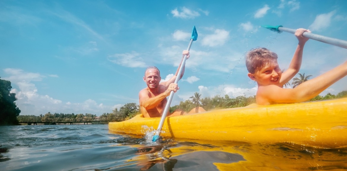 father and son kayaking | Coastline Realty Vacations