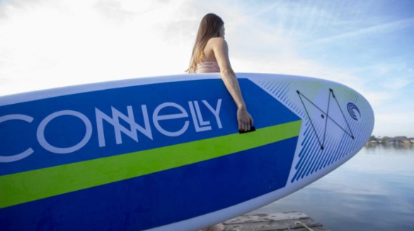 girl holding paddleboard | Coastline Realty