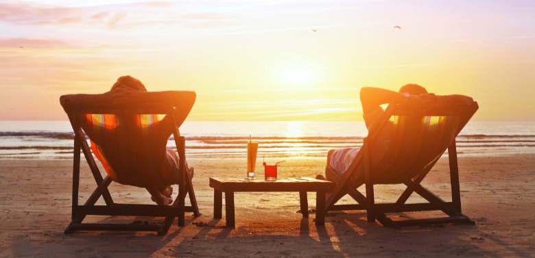 couple relaxing on the beach together | Coastline Realty