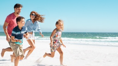 family having fun on the beach | Coastline Realty