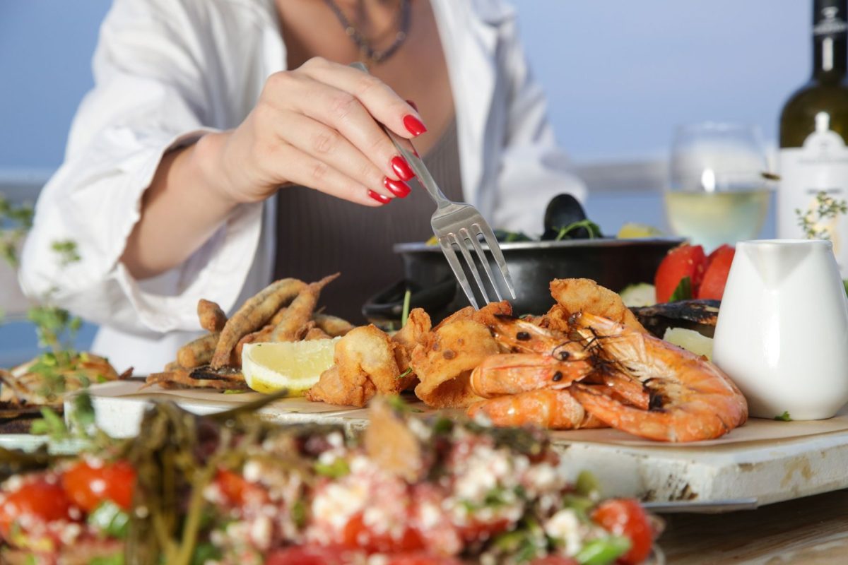 woman dining on shrimp and seafood plate